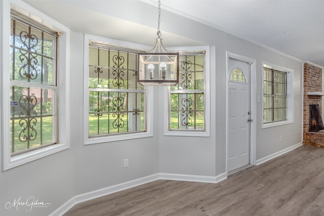 2011 Crabapple, Shreveport, LA 71118 - unfurnished dining area featuring a chandelier, crown molding, wood finished floors, and a fireplace