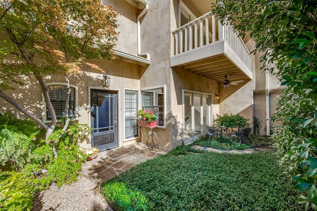 entrance to property featuring ceiling fan and a balcony