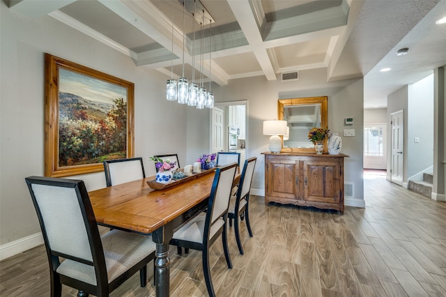 dining room featuring ornamental molding, light wood-type flooring, beamed ceiling, and coffered ceiling