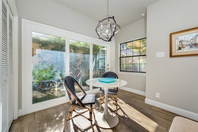 dining space with dark hardwood / wood-style flooring and a notable chandelier