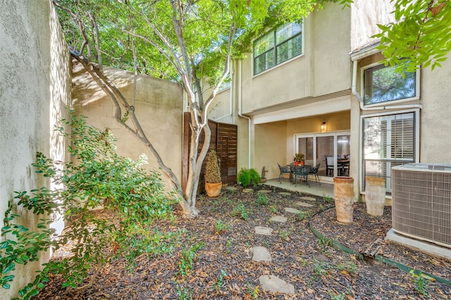 rear view of house with central AC unit and a patio