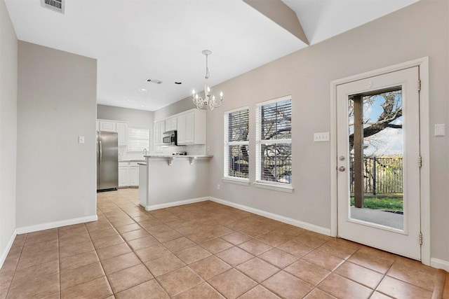 kitchen with a breakfast bar, plenty of natural light, white cabinets, and stainless steel appliances