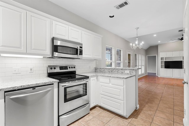 kitchen with white cabinetry, stainless steel appliances, and vaulted ceiling