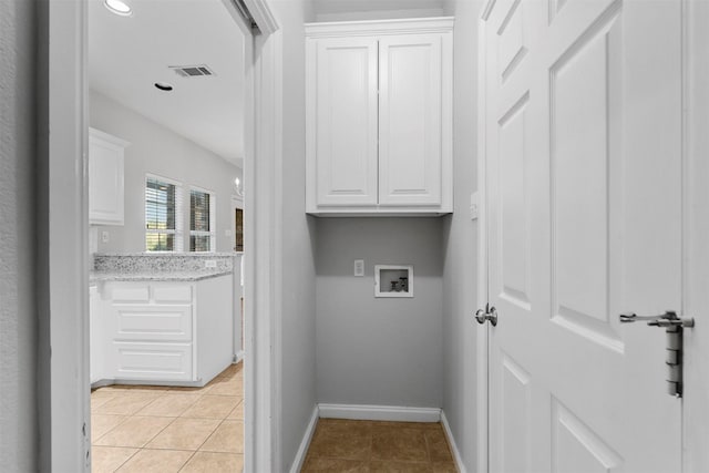 laundry room featuring cabinets, light tile patterned floors, and hookup for a washing machine