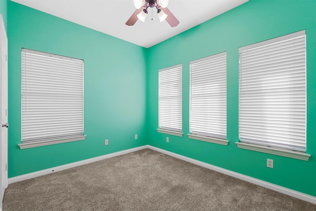 empty room with carpet floors, plenty of natural light, and ceiling fan