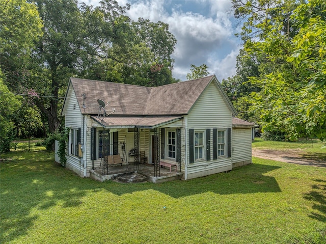 rear view of property with a porch and a yard