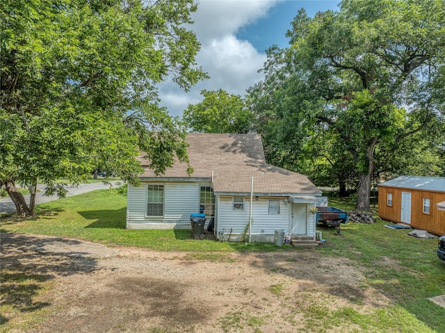 702 S Barrett Ave, Denison, TX 75020 - back of property with entry steps, a yard, and a shingled roof