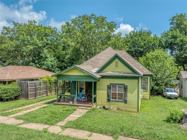 bungalow featuring covered porch and a front lawn