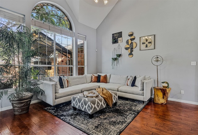 living room with dark hardwood / wood-style flooring and high vaulted ceiling