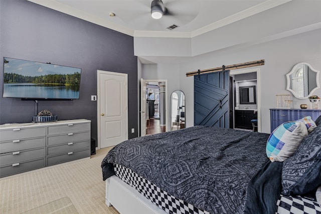 bedroom with ensuite bathroom, ceiling fan, a barn door, ornamental molding, and light colored carpet