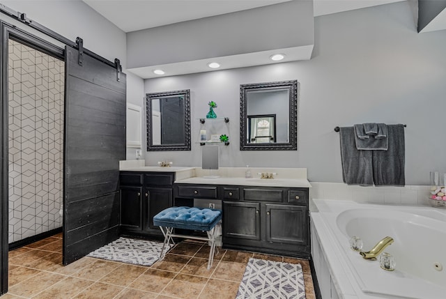 bathroom with tile patterned floors, a bathing tub, and vanity