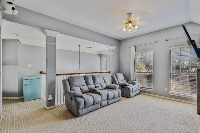 carpeted living room with ceiling fan, ornate columns, and crown molding