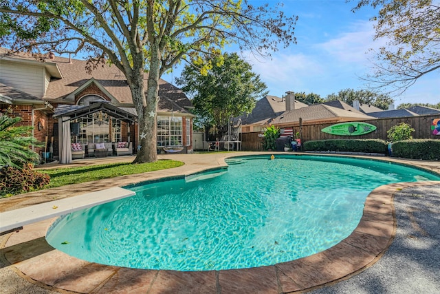 view of pool with a diving board and a patio