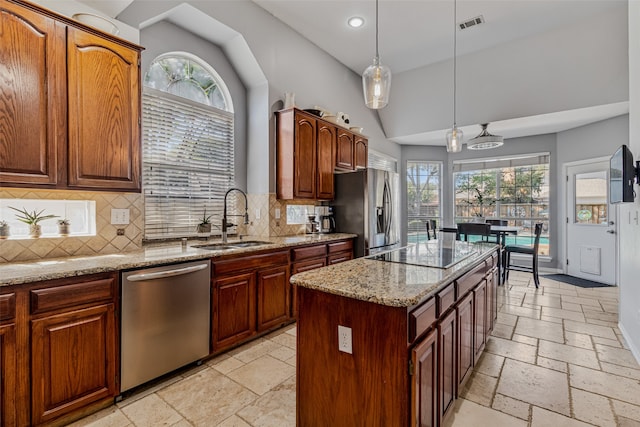 kitchen with pendant lighting, a center island, sink, decorative backsplash, and stainless steel appliances