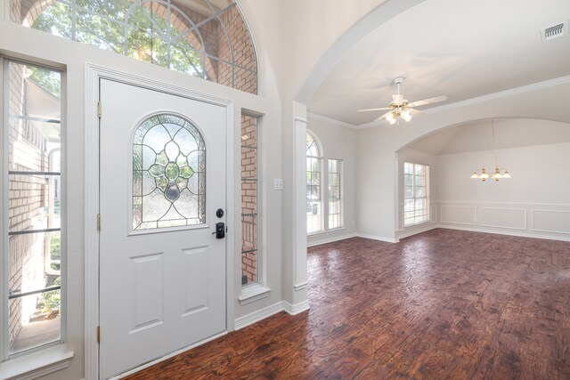 foyer entrance featuring ceiling fan with notable chandelier, dark hardwood / wood-style floors, and crown molding