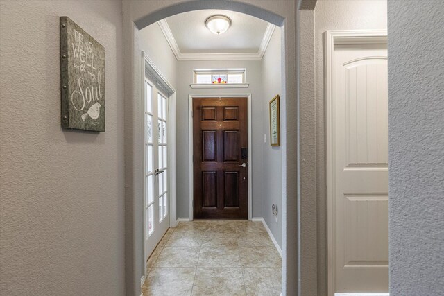 tiled foyer with ornamental molding and french doors