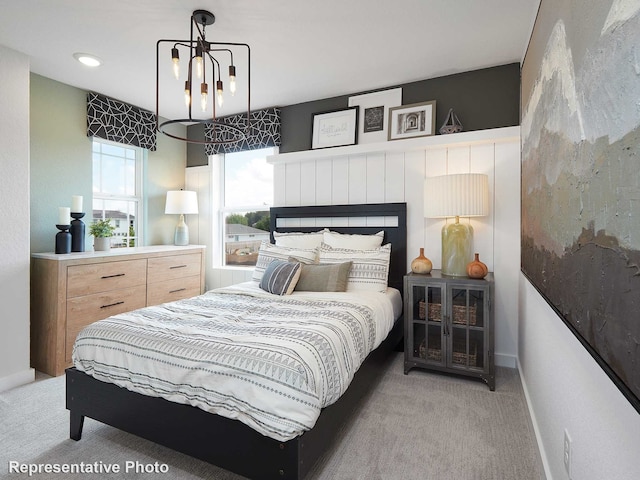 bedroom with an inviting chandelier and light carpet