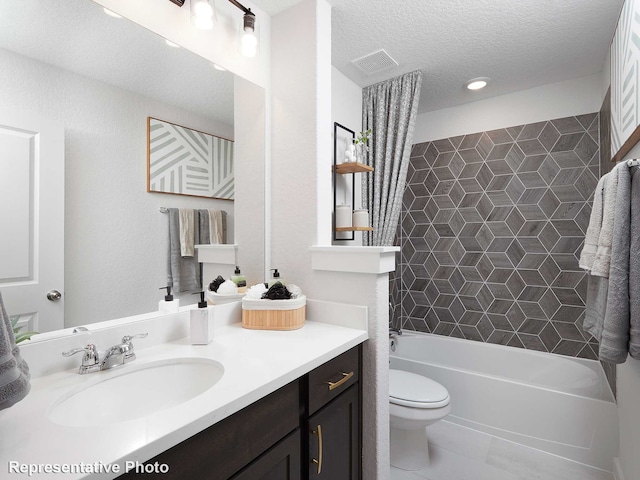 full bathroom featuring tile patterned floors, toilet, tiled shower / bath combo, a textured ceiling, and vanity