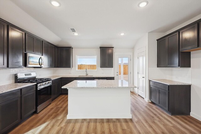 kitchen with light wood-type flooring, dark brown cabinets, and stainless steel appliances