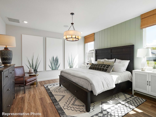 bedroom featuring wood walls and wood-type flooring