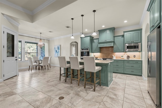 kitchen featuring hanging light fixtures, an island with sink, ornamental molding, and stainless steel appliances