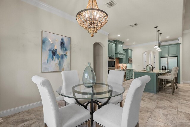 dining area featuring ornamental molding, a chandelier, and sink