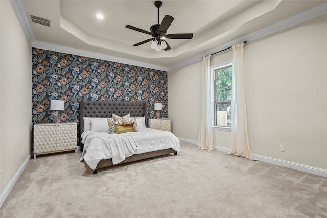 bedroom with ornamental molding, light carpet, ceiling fan, and a tray ceiling