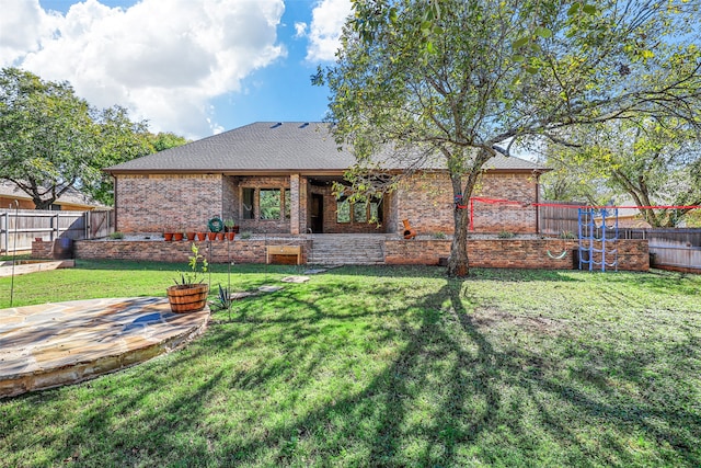 back of property featuring a patio and a lawn