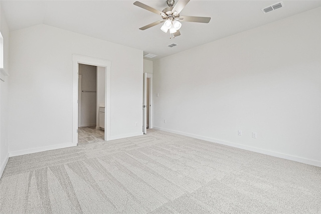 unfurnished bedroom featuring lofted ceiling, light colored carpet, visible vents, ceiling fan, and baseboards