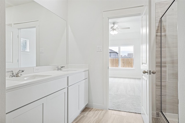 bathroom with double vanity, ceiling fan, baseboards, and a sink