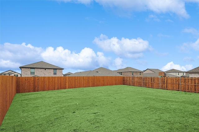 view of yard with a fenced backyard and a residential view