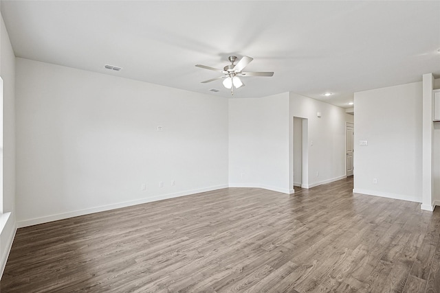 spare room featuring visible vents, ceiling fan, baseboards, and wood finished floors