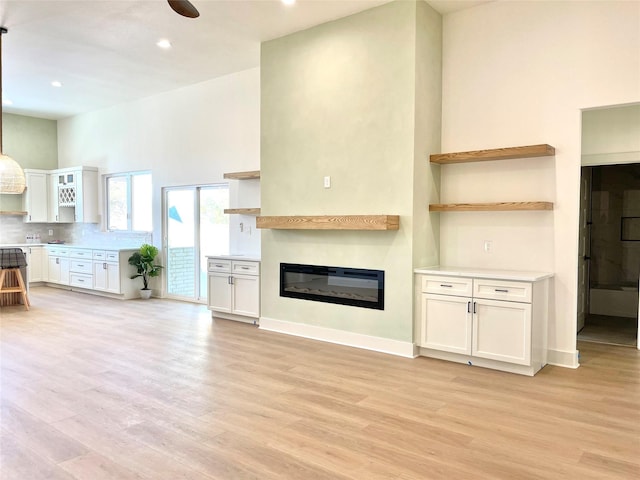 unfurnished living room featuring ceiling fan and light hardwood / wood-style flooring