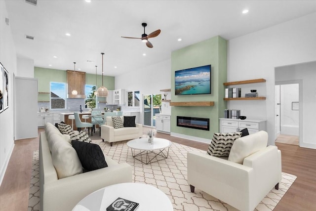 living room featuring ceiling fan and light wood-type flooring