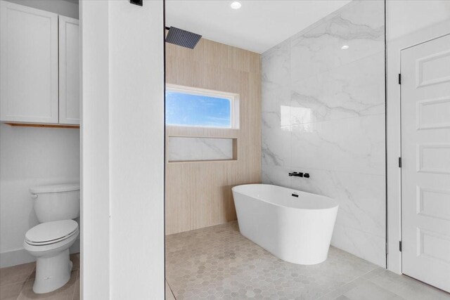 bathroom featuring tile patterned floors, toilet, shower with separate bathtub, and tile walls