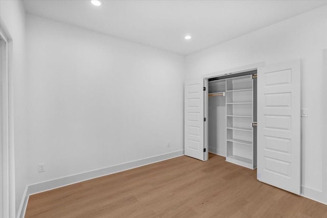 unfurnished bedroom with light wood-type flooring and a closet