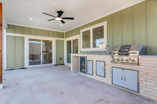 view of patio featuring grilling area, an outdoor kitchen, sink, ceiling fan, and beverage cooler