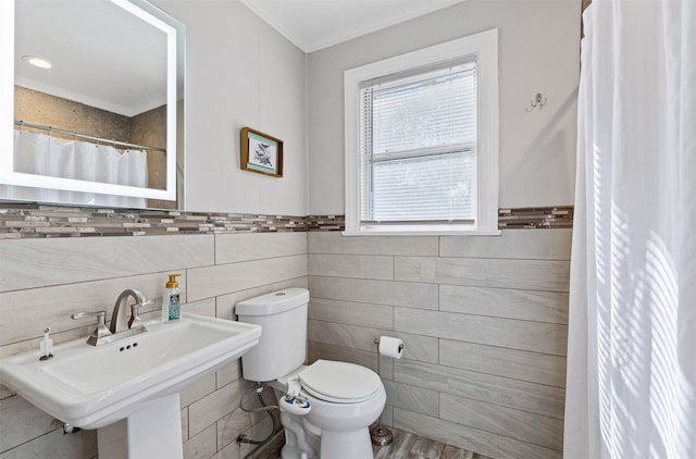 bathroom featuring ornamental molding, sink, tile walls, and toilet