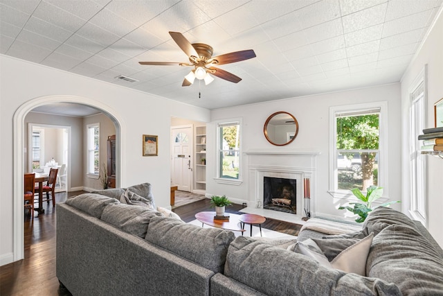 living room with dark wood-type flooring and ceiling fan