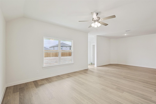 unfurnished room featuring lofted ceiling, light wood-style flooring, baseboards, and ceiling fan