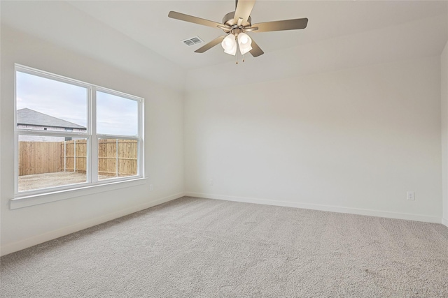 carpeted empty room with ceiling fan, visible vents, and baseboards