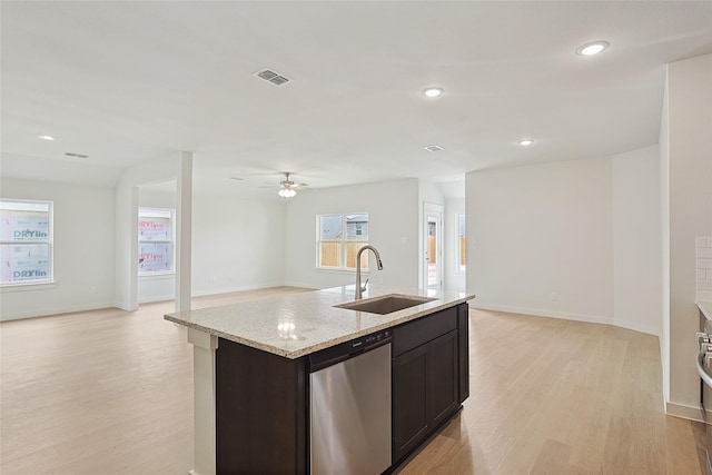 kitchen featuring visible vents, dishwasher, open floor plan, a kitchen island with sink, and a sink