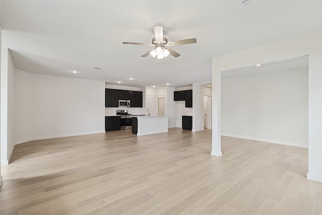 unfurnished living room with recessed lighting, visible vents, ceiling fan, a sink, and light wood-type flooring