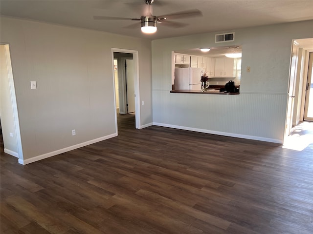 unfurnished living room with ceiling fan and dark wood-type flooring