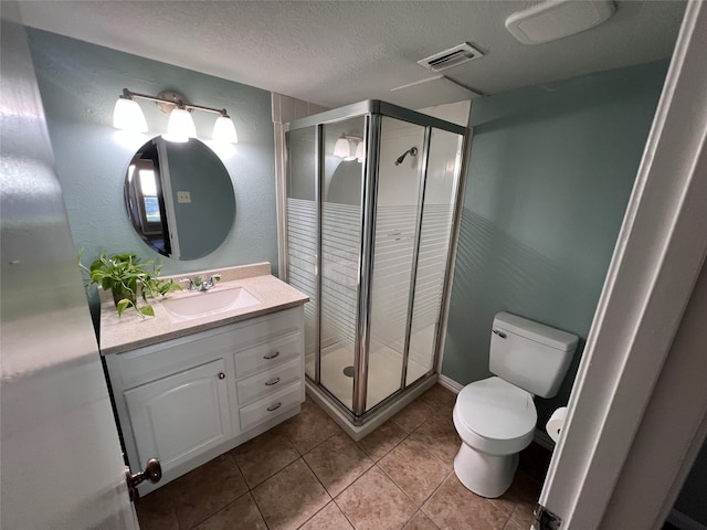 bathroom with vanity, a textured ceiling, tile patterned floors, and a shower with shower door