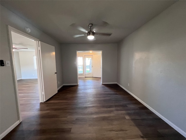 empty room with ceiling fan and dark wood-type flooring