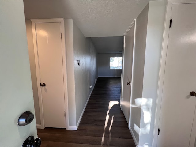 hallway featuring dark wood-type flooring and a textured ceiling