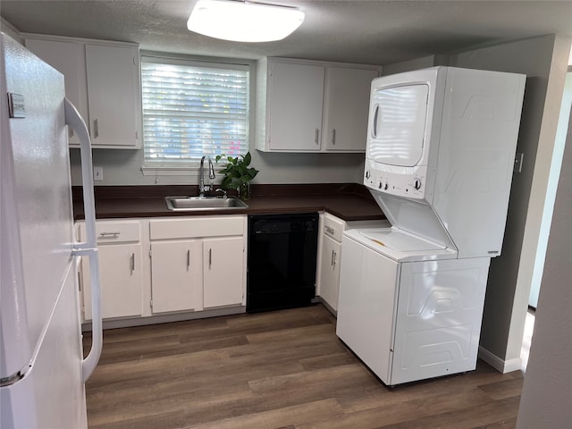 washroom with a textured ceiling, stacked washer / dryer, sink, and dark wood-type flooring