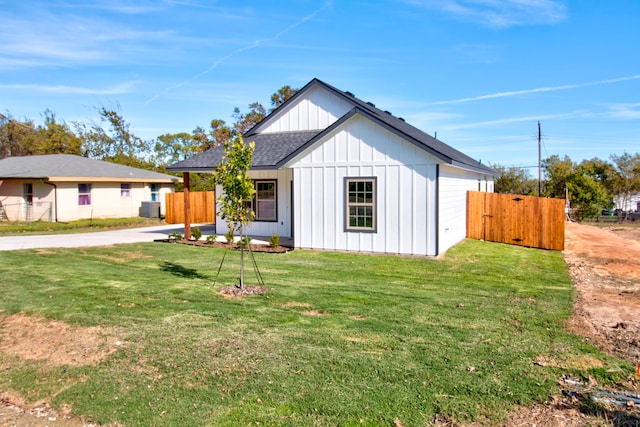 view of front of home with central AC and a front yard