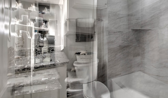 bathroom featuring tiled shower and vanity